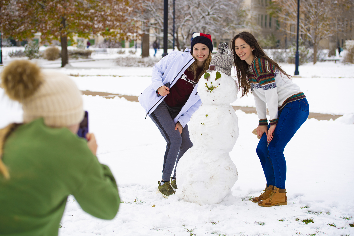 Bradley U. girl students with a snowman in winter scene