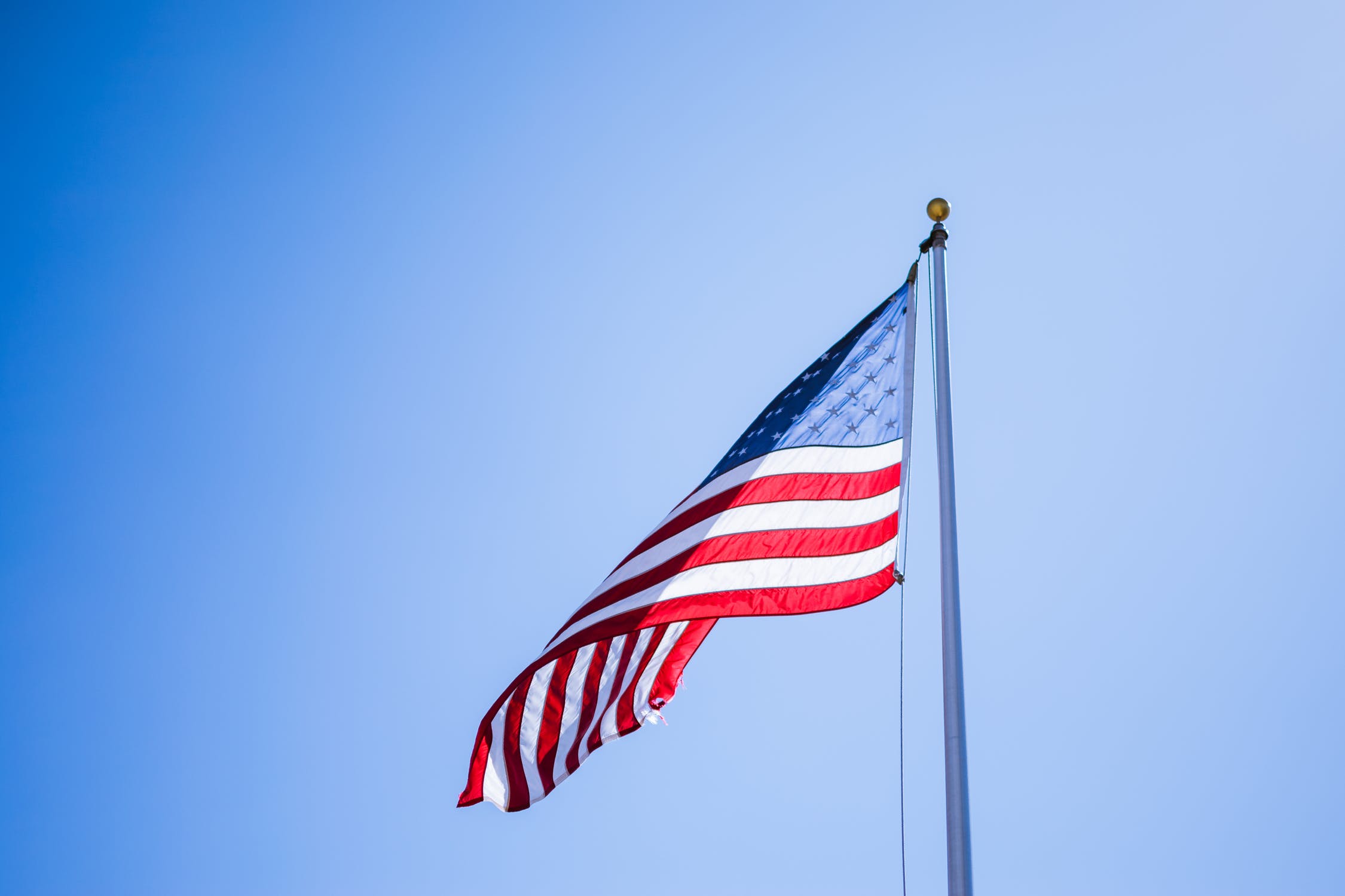 Waiving Flag on pole on bright day